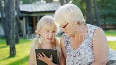 <strong>外婆</strong>和孙女正在家后院休息，他们一起看着碑，交流..